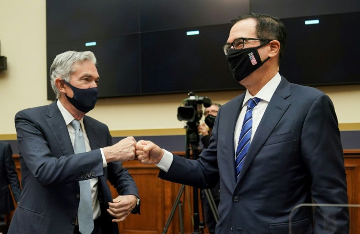 US Federal Reserve Chair Jerome Powell (L) fist-bumps Treasury Secretary Steven Mnuchin (R) following a House Financial Services Committee hearing where he urged Congress to provide more relief to the economy as a "bridge"