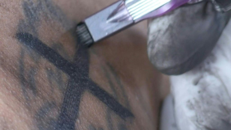 Heavily-tattooed Philippine inmates wince in pain as fellow prisoners use improvised tattooing machines to cover up symbols identifying their gang affiliation as part of an official programme aimed at reducing violence.