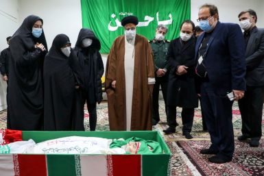 Iran's Judiciary Chief Ayatollah Ebrahim Raisi (C) pays respects to the body of slain scientist Mohsen Fakhrizadeh among his family, in the capital Tehran on November 28, 2020
