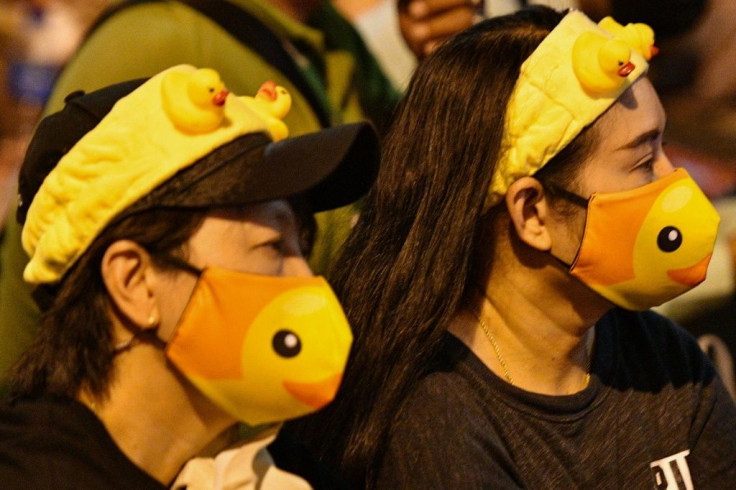 Pro-democracy protesters wear duck-themed masks and hairbands at a rally in Bangkok