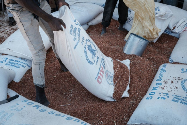 Men unpack sorghum at the Um Raquba refugee camp, which now houses tens of thousands of people