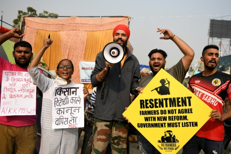 Farmers hold placards and shout slogans during a protest at the Delhi-Haryana state border