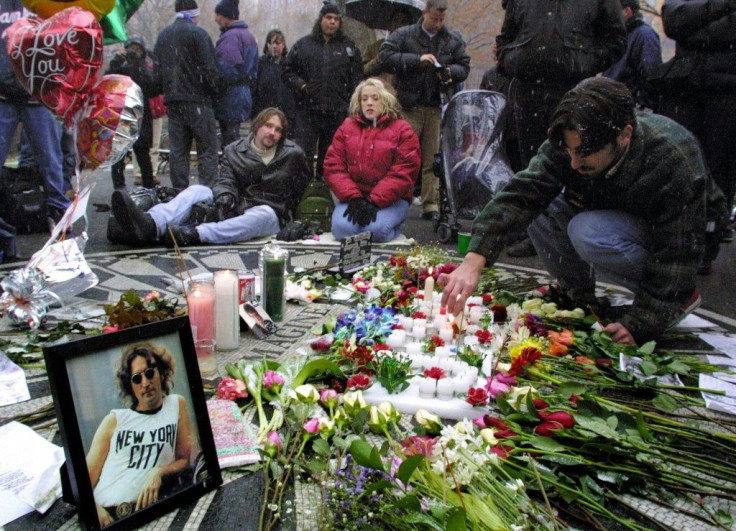 People gather at the memorial to John Lennon in the Strawberry Fields section of Central Park in New York, on the 20th anniversary of his murder in 2000