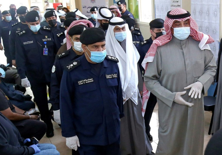 Kuwaiti Prime Minister Sheikh Sabah al-Khaled al-Sabah (R) arrives to cast his votes at a polling station in Kuwait City during parliamentary elections on December 5, 2020
