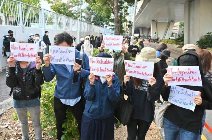 Supporters show signs for Hong Kong pro-democracy activists Agnes Chow, Ivan Lam and Joshua Wong outside a court on December 2, 2020 after the three were given jail time