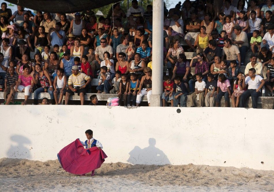 Dwarf bullfighter Jorge Vega from Los Enanitos Toreros waits in the ring, as the audience watches, in Cancun