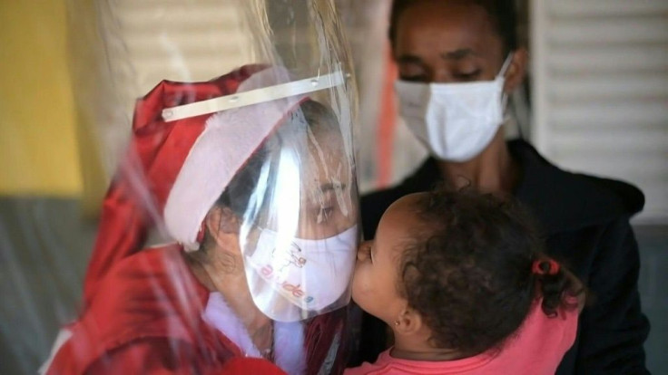 Dressed as Mrs Claus, Fatima Sanson offers gifts and hugs to disadvantaged children in Belo Horizonte every Christmas, but this year it's with a difference. As Brazil continues to face the deadly coronavirus pandemic, a sanitised curtain has been installe