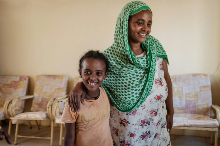 Shalom is all smiles as she is reunited with her mother Otash at a refugee reception centre in neighbouring Sudan after a whole month apart