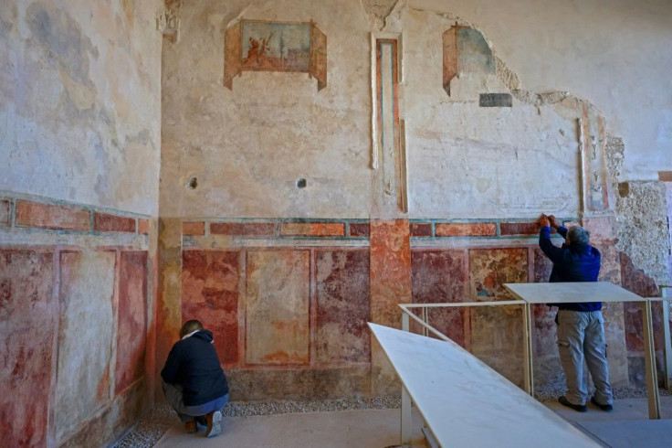 Specialists from the Israel Antiquities Authority restore an ancient wall painting in Herod's palace-fortress