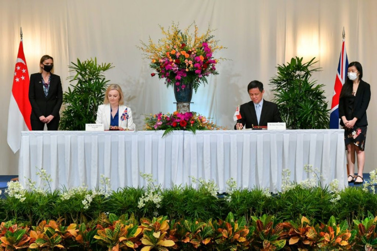 Britain's International Trade Secretary Liz Truss (2nd L) and her counterpart Chan Chun Sing (2nd R) signed the free-trade deal in Singapore
