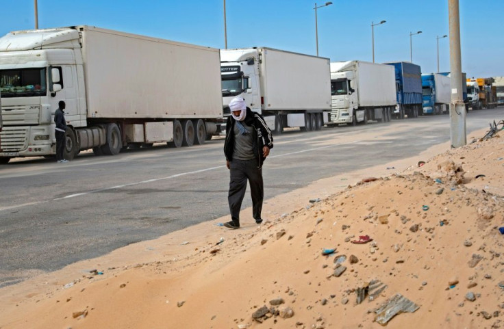 A man walks past trucks near the border in Guerguerat, located in the Western Sahara, in November 2020