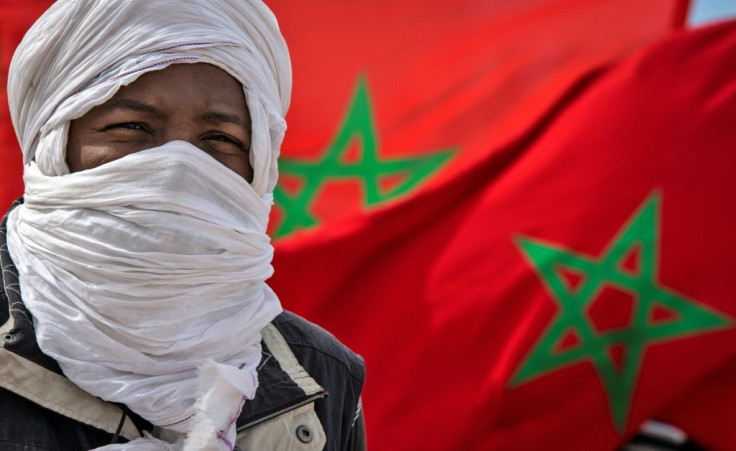 A tribesman stand in front of a Moroccan flags near the border in Guerguerat located in  Western Sahara in November 2020