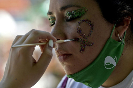 A woman has a female symbol painted on her cheek during a pro-abortion demo outside the Argentine Congress in Buenos Aires, on December 10, 2020