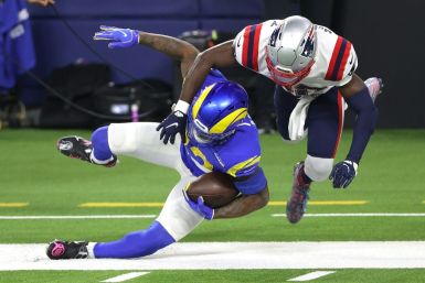Los Angeles Rams rookie running back Cam Akers, left, is tackled and pushed out of bounds by Devin McCourty of the New England Patriots during the first half of an NFL game at SoFi Stadium