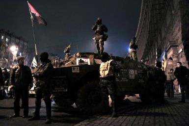 Maidan activists stand on an armoured vehicle in central Kiev in February 2014