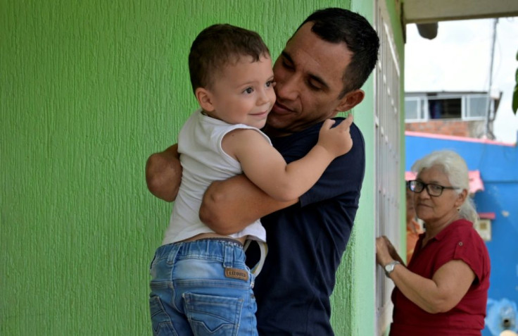 Colombian paralympian Juan Jose Florian plays with his son Juan Jose at home in the southeastern town of Granada, in November 2020