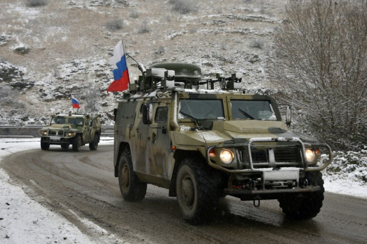Russian peacekeeping military vehicles drive outside the town of Lachin southwest of Nagorno-Karabakh on November 29, 2020, after six weeks of fighting between Armenia and Azerbaijan