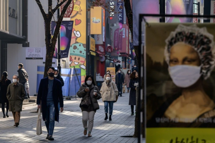 Shoppers in masks walk through Myeongdong in Seoul. Covid cases in the South Korean capital are spiking