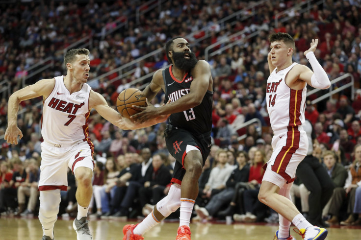James Harden #13 of the Houston Rockets drives to the basket defended by Goran Dragic #7 of the Miami Heat and Tyler Herro #14
