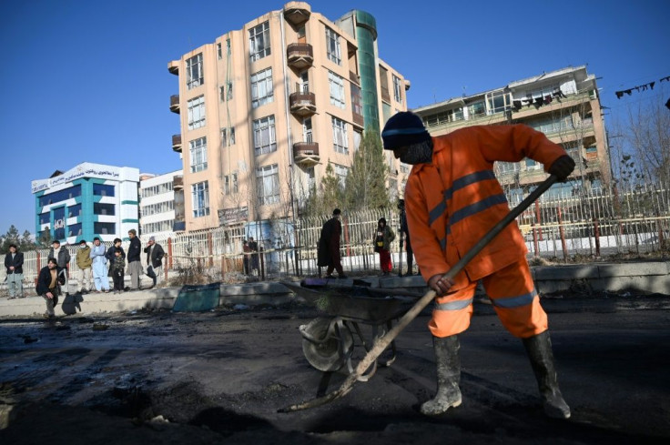 A municipal worker clears debris from the site of a rocket attack in the Afghan capital