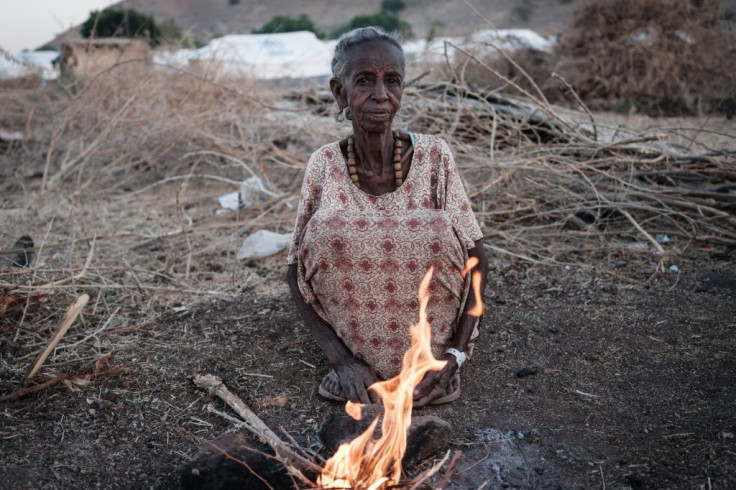 Ethiopian Arrafu Mbaye, 70-year-old who fled the Tigray conflict, burns wood to cook at the Um Raquba refugee camp