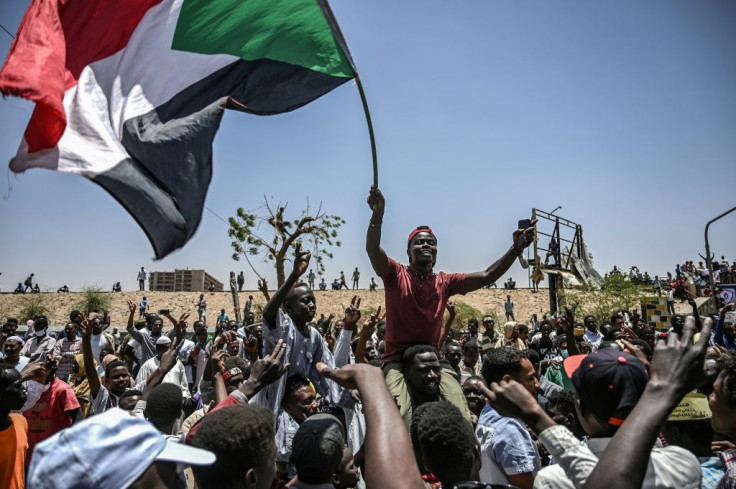 Sudanese protesters wave the national flag outside army headquarters in Khartoum in April 2019; demonstrations continued even after dictator Omar al-Bashir's fall, to force the military into sharing power