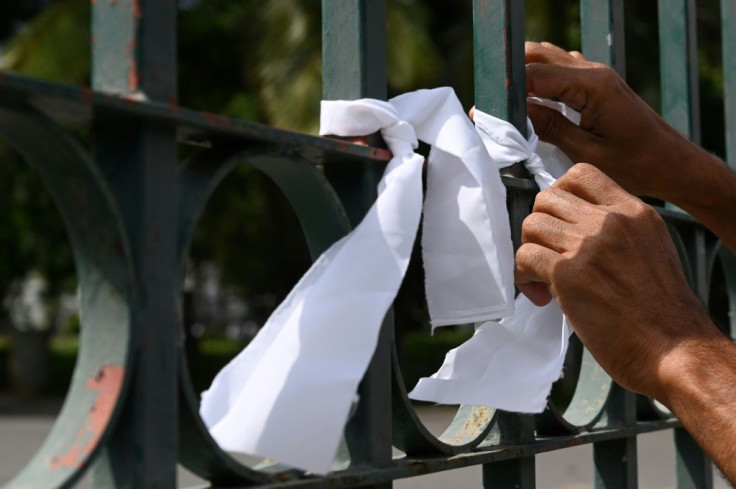 People tied white riboons on a cemetery fence in Colombo to protest against the forced cremation of Coronavirus victims