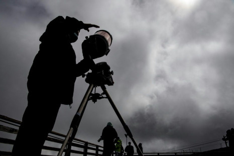 Simon Angel, an astronoma from the Catholic University of Chile, sets up his telescope to view the eclipse