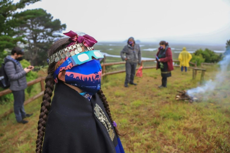 A Mapuche indigenous family watch the total solar eclipse in Carahue, Araucania region in southern Chile