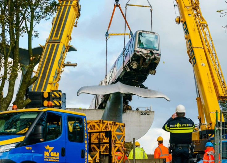 Workers lift a subway train from the top of a sculpture of a whale's tail at Spijkenisse, near the port city of Rotterdam on November 3