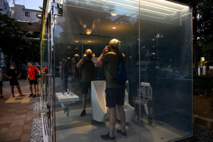 A man uses a transparent toilet at Haru-no-Ogawa Community Park in the Shibuya district of Tokyo