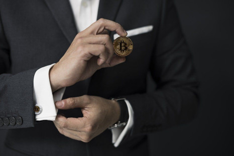 Man in suit holding bitcoin