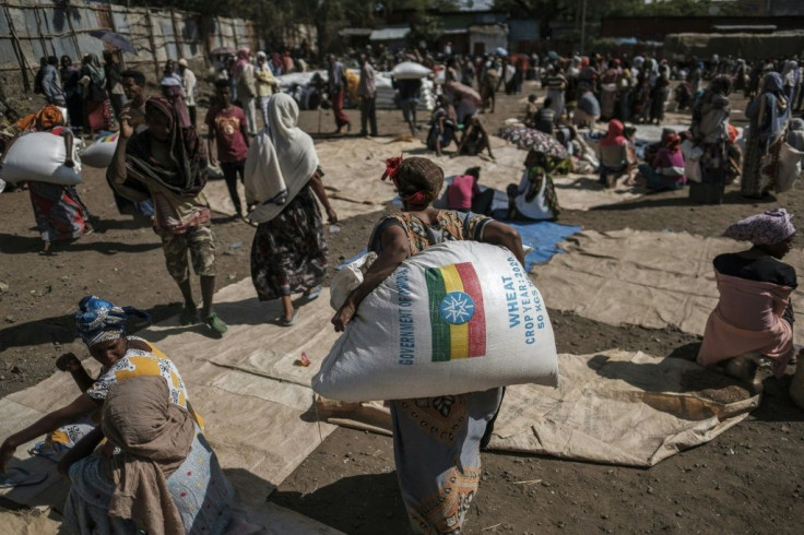 Residents in the Tigray town of Alamata collect sacks of wheat distributed by officials
