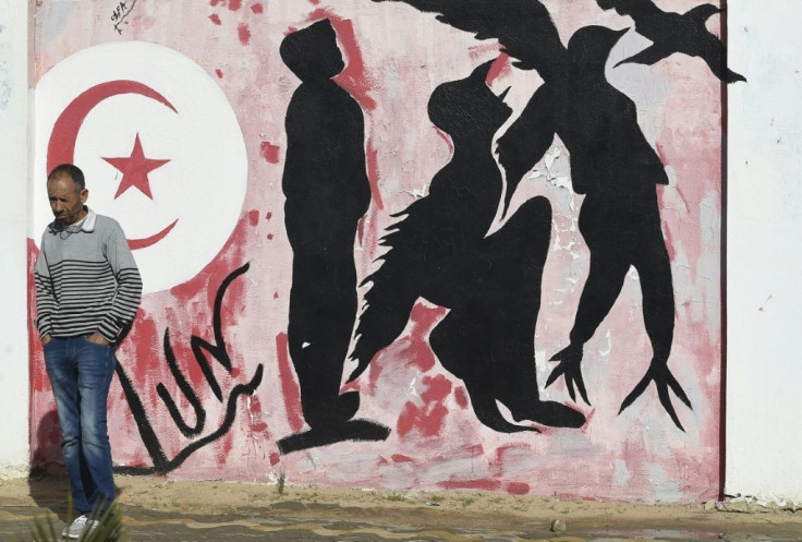 Graffiti depicts silhouettes of a man metamorphosing into a bird symbolising freedom, in Sidi Bouzid town centre
