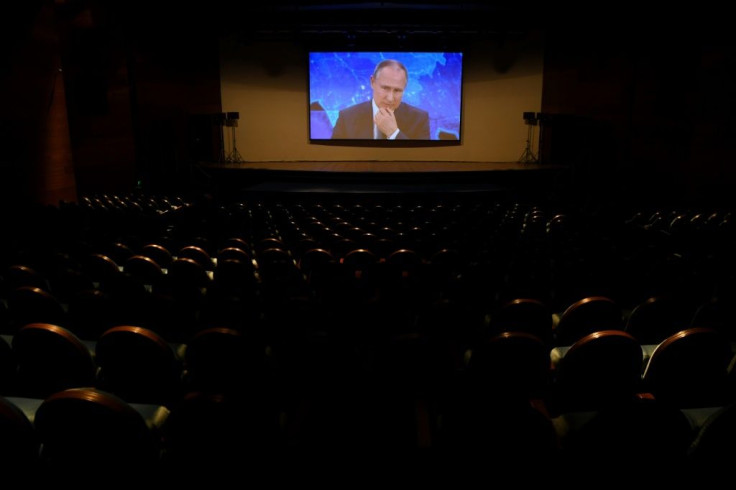 Russian President Vladimir Putin appears on a screen in a hall at the World Trade Centre's congress centre as he holds his annual press conference via a video link from the Novo-Ogaryovo state residence, in Moscow