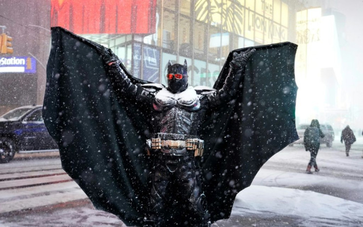 A person wearing a Batman costume stands under the snow in Times Square in New York City, December 16, 2020