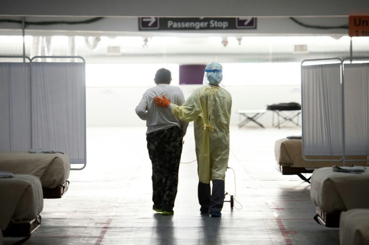 A nurse helps a patient with Covid-19 at a parking lot converted into a care unit in Reno, Nevada