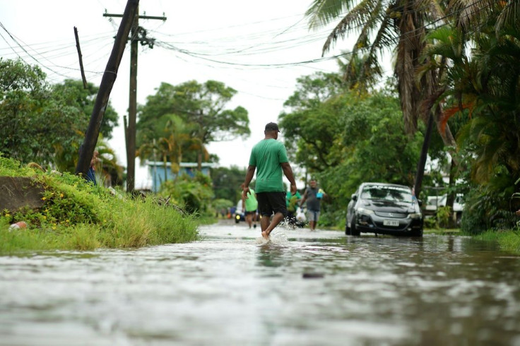 Residents wade through flooded streets in Fiji's capital city of Suva on December 16, 2020, ahead of super cyclone Yasa
