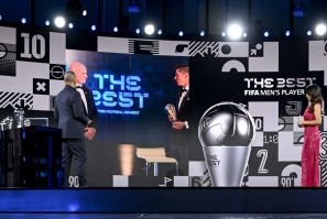 FIFA President Gianni Infantino (C-L) appears on a screen awarding 'The Best' men's player award to Bayern Munich striker Robert Lewandowski
