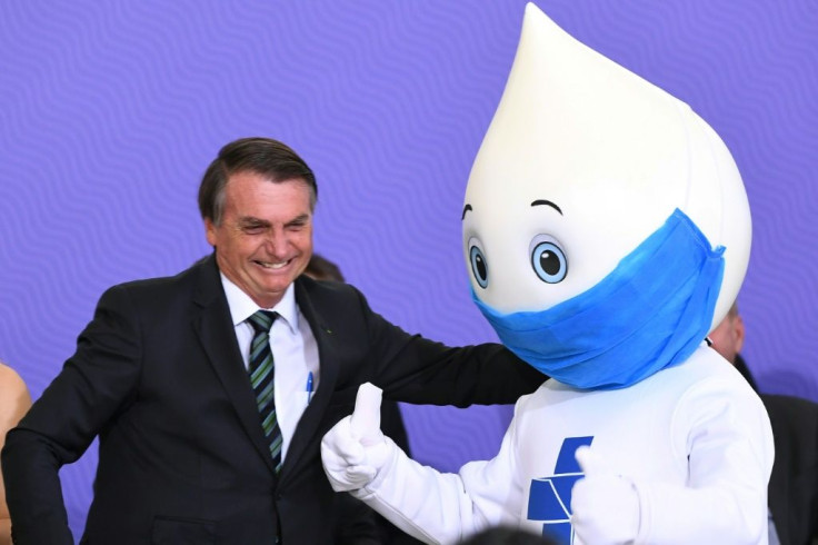 Brazil President Jair Bolsonaro, shown here with the country's immunization mascot, has been accused of sabotaging his own government's Covid-19 program by regularly speaking out against vaccines