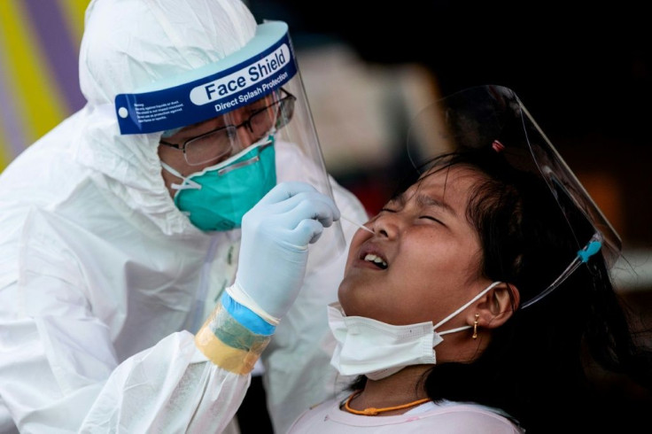 Medical officials test a girl for coronavirus at the seafood market in Samut Sakhon