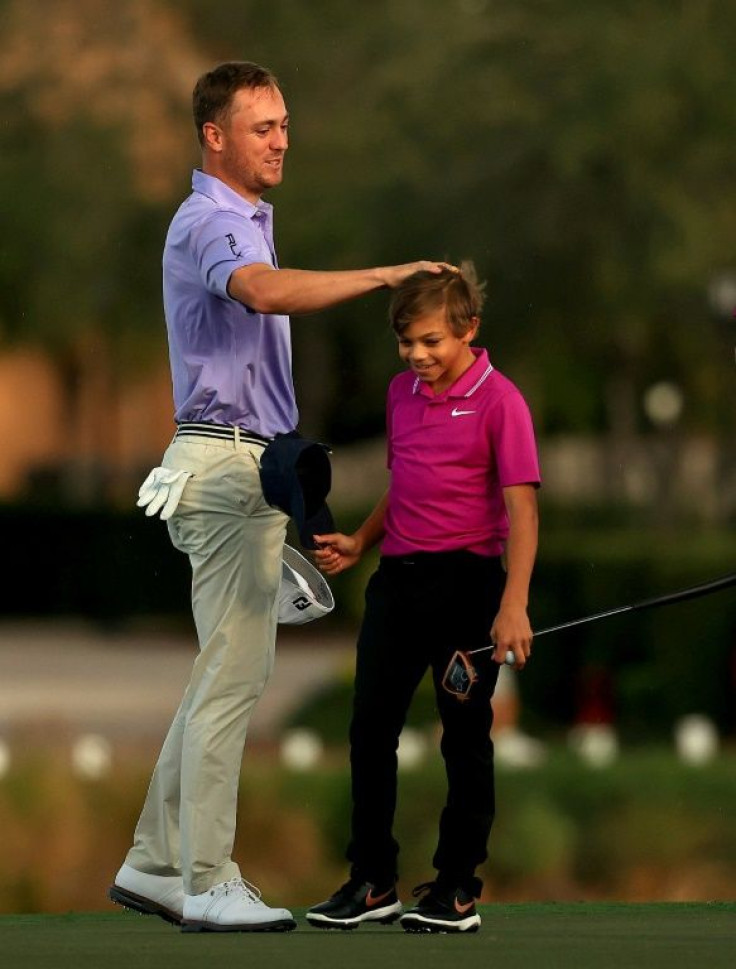 Justin Thomas congratulates Charlie Woods on the 18th green in the first round of the PNC Championship in Orlando, Florida