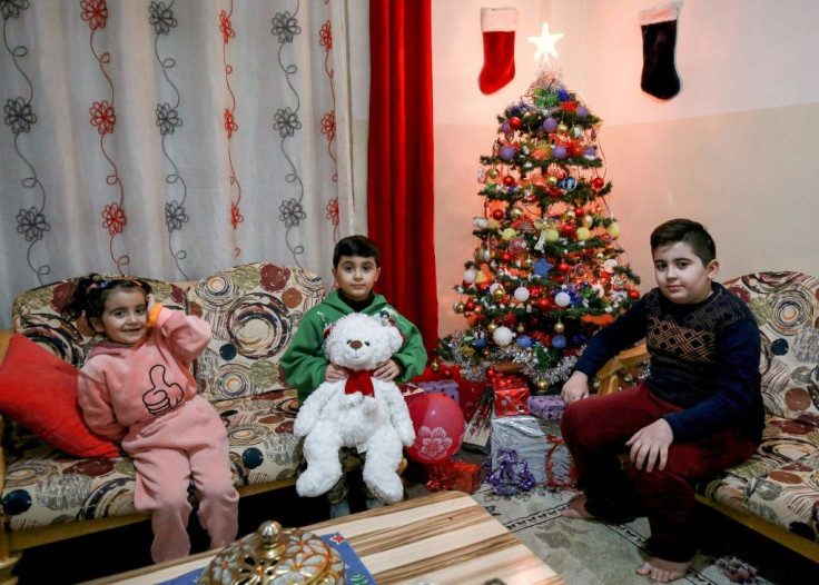Ameel Saeed's children sit by a small Christmas tree at the home in Jordan, which has hosted waves of Iraqi refugees starting with the 1990 first Gulf War, the 2003 US-led invasion of Iraq and the 2014 emergence of the Islamic State jihadist group