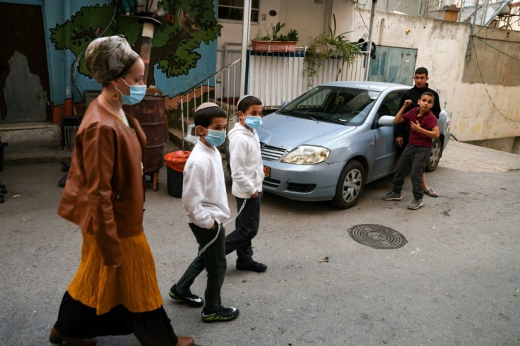 Nira Rabinowicz walks in Silwan with two of her seven children, as settler groups say their aim is not to force out Palestinians, but to buy available properties