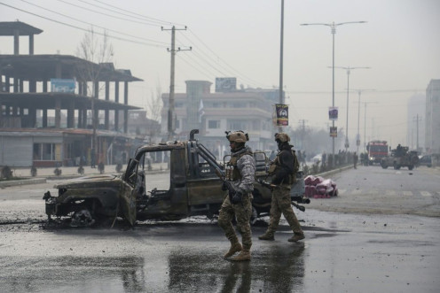 Afghan security force members stand at the site of the attack in Kabul on December 20, 2020
