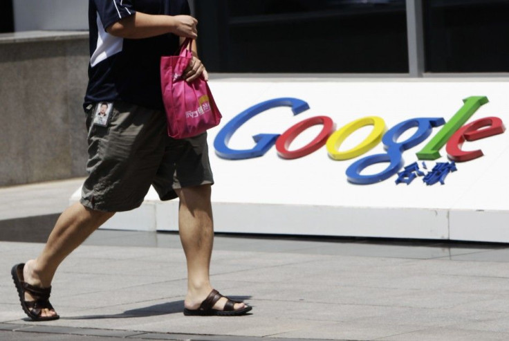An employee walks past the logo of Google