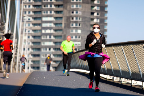 A runner wearing the protective mask crosses the Erasmus Bridge in Rotterdam