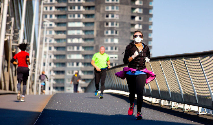 A runner wearing the protective mask crosses the Erasmus Bridge in Rotterdam