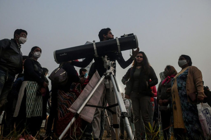 People stand in a queue to see a "great conjunction" of Jupiter and Saturn, in Kolkata, India on December 21, 2020