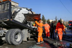 Municipal workers clean up debris from the site of a bomb attack in Kabul that killed five people, including two women prison doctors
